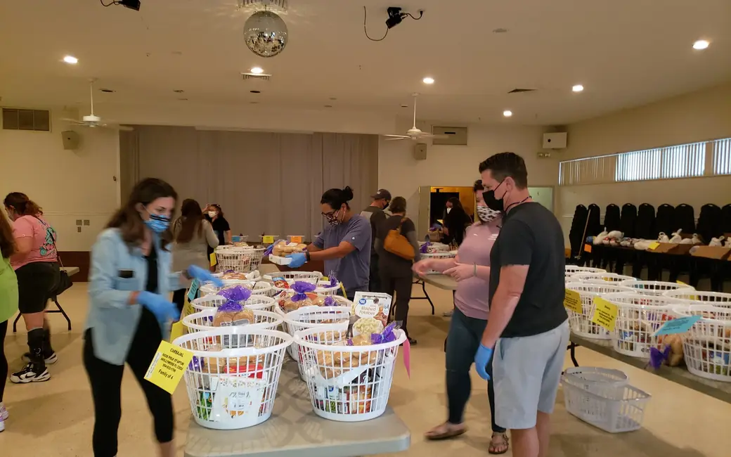 Volunteers in masks packing Thanksgiving baskets in Jaycee Hall, 2020
